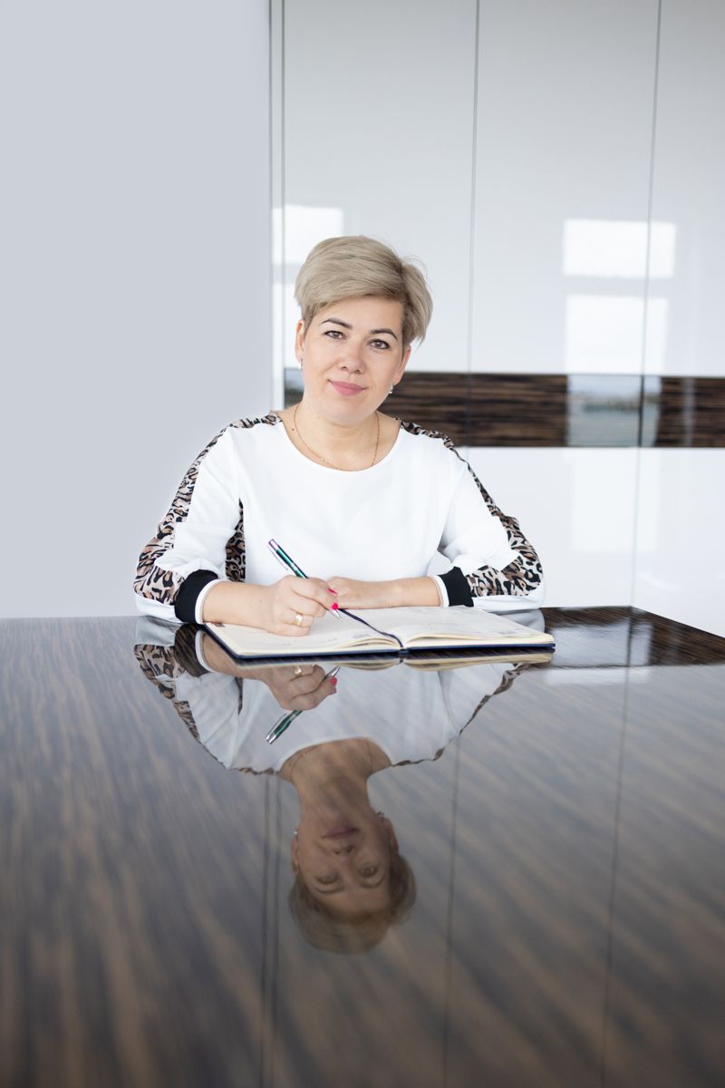 fotografia biznesowa kobieta siedząca przy biurku z notesem i długopisem