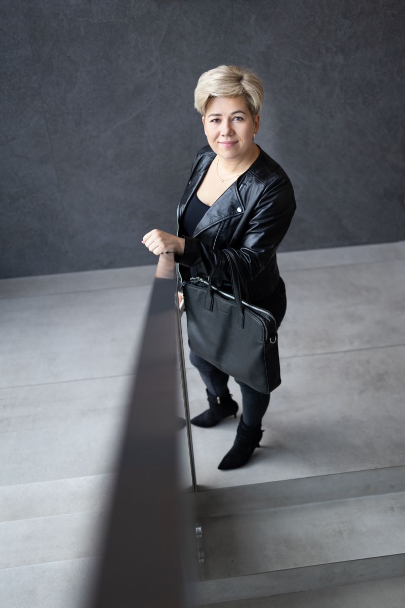 fotografia biznesowa kobieta w skórzanej kurtce stojąca przy poręczy