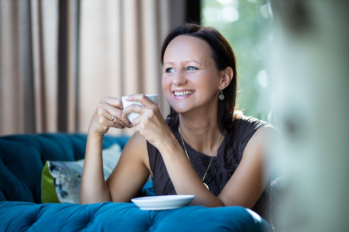 fotografia biznesowa uśmiechnięta kobieta z filiżanką kawy
