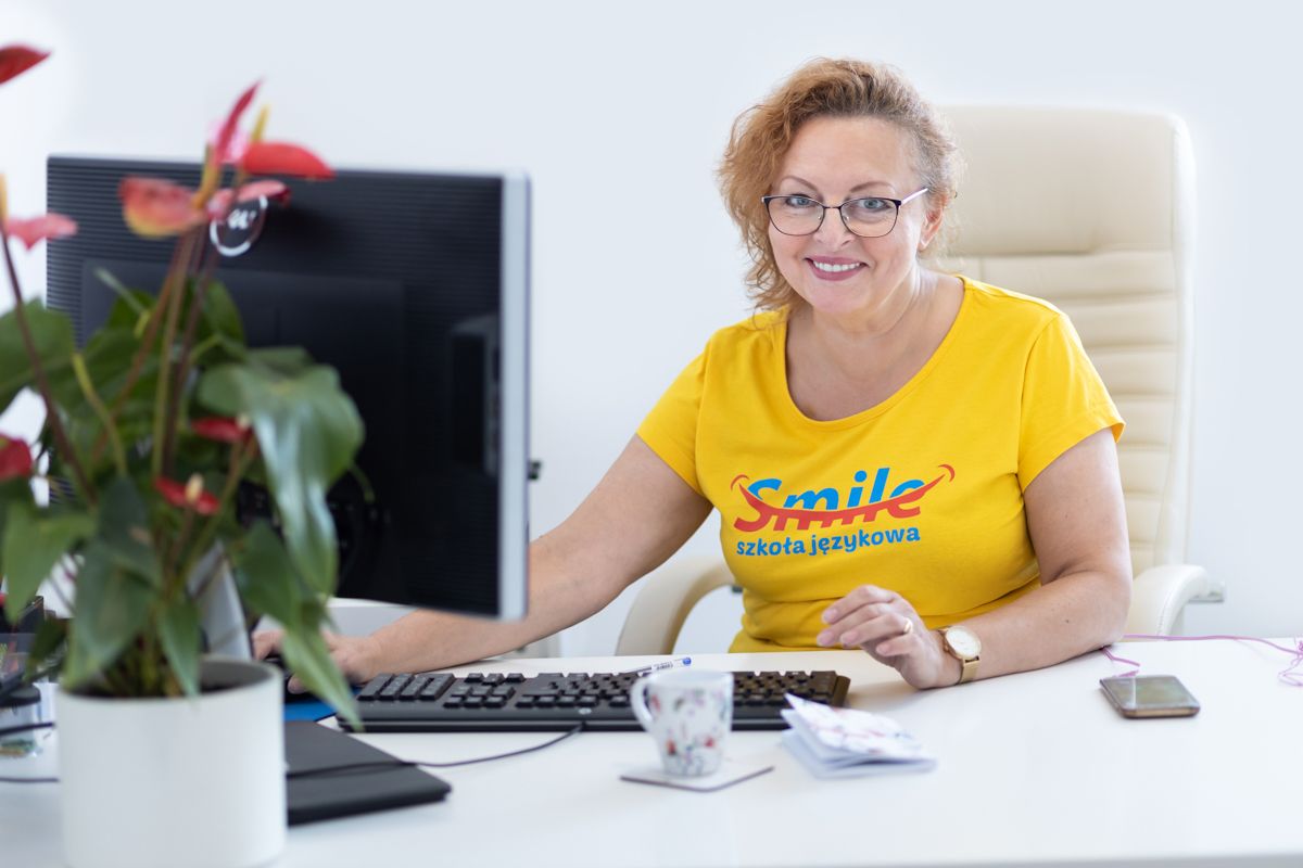 fotografia biznesowa kobieta w żółtej koszulce smile przy biurku